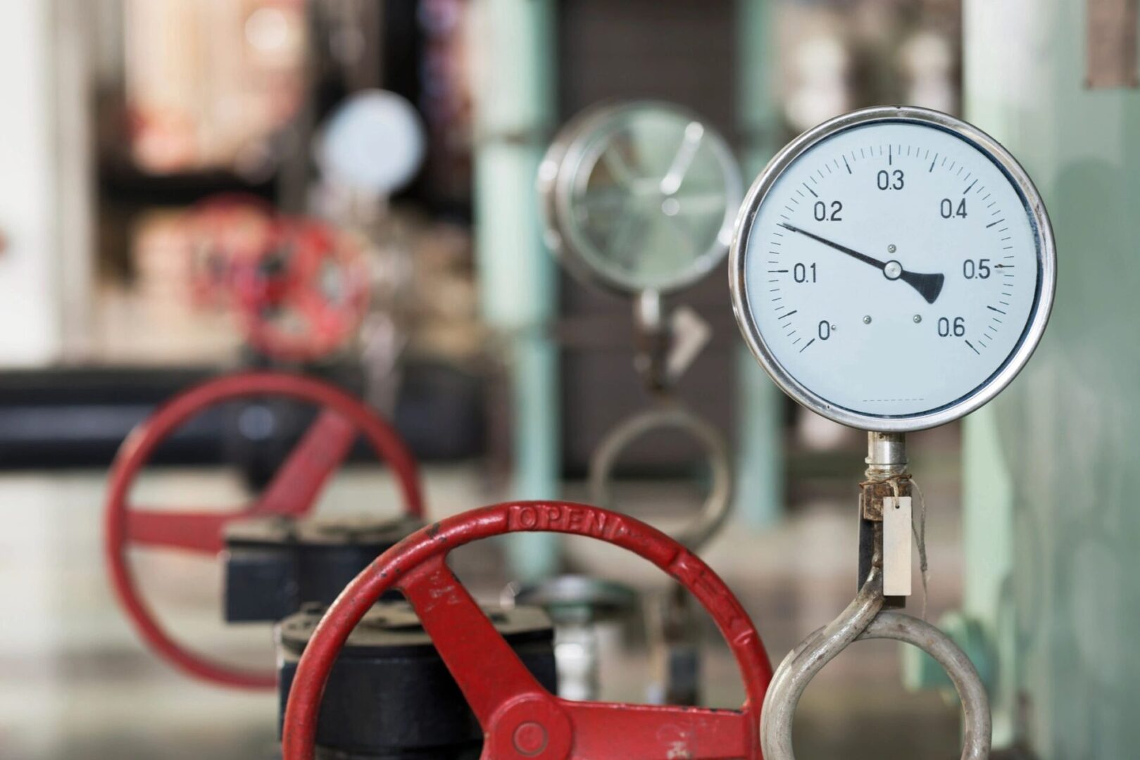 A closeup shot of a pressure gauge with a red handle